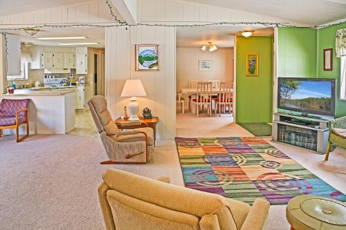a living room with a couch and a tv and a kitchen at Huckleberry Cabin in Dryden