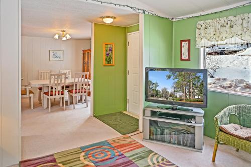 a living room with a tv and a dining room at Huckleberry Cabin in Dryden