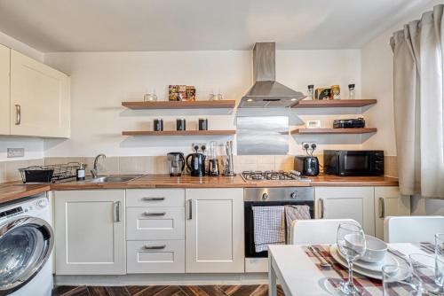 a kitchen with white cabinets and a stove top oven at Central Nottingham 3 bed house with Driveway in Nottingham