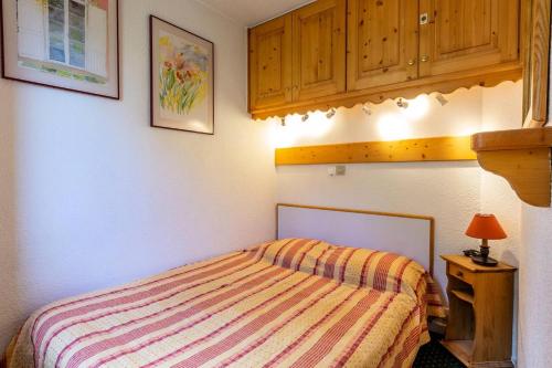 une chambre avec un lit et une armoire en bois dans l'établissement Résidence Plan Du Lac - PLAN DU LAC 313 MAE-4221, à Les Allues