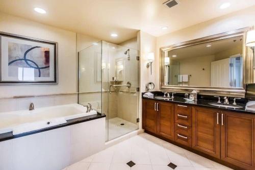 Un baño con bañera, lavabo y ducha. en MGM 32809 Signature Studio Strip View, en Las Vegas