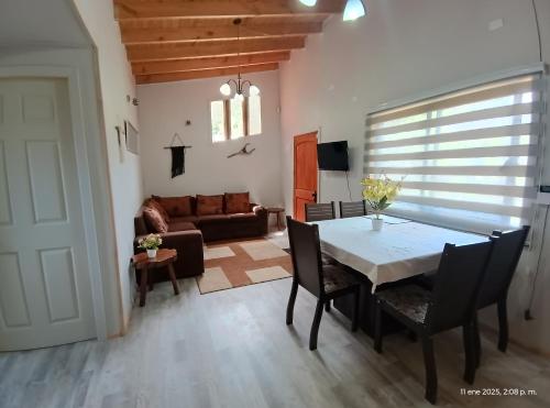 a dining room with a table and chairs and a couch at Casa para 4 o 5 personas en Llifen a metros de Supermercado farmacia panaderias y playas in llifen