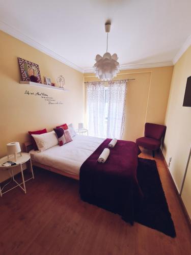 a bedroom with a large bed and a chair at DOWNTOWN-GuestHouse in Olhão