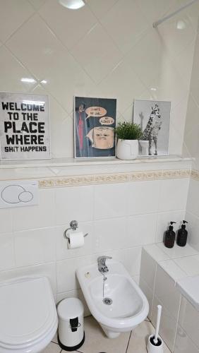 a white bathroom with a toilet and a sink at DOWNTOWN-GuestHouse in Olhão