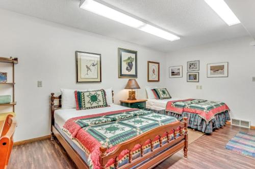 a bedroom with two beds and a table with a lamp at Loonsight in Minocqua