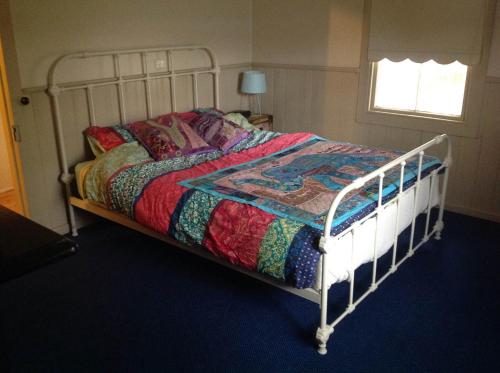 a bed with a colorful quilt on it in a bedroom at Pemberton in Beechworth