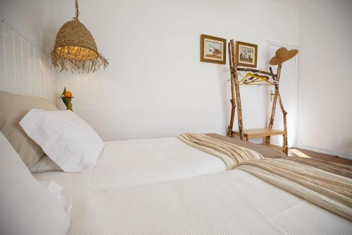 a bedroom with a white bed and a chandelier at Romans House in Évora