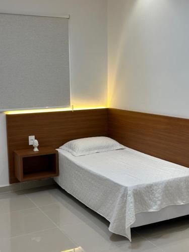 a bedroom with a bed with a wooden headboard at Concierge House Exclusiva in Marabá