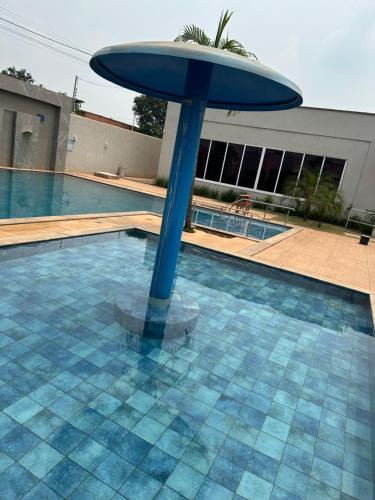 a blue umbrella in the middle of a swimming pool at Concierge House Exclusiva in Marabá