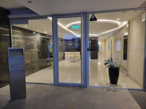 an office entrance with glass doors and a potted plant at Departamento moderno con cochera y parrilla, amplio y luminoso in Puerto Madryn