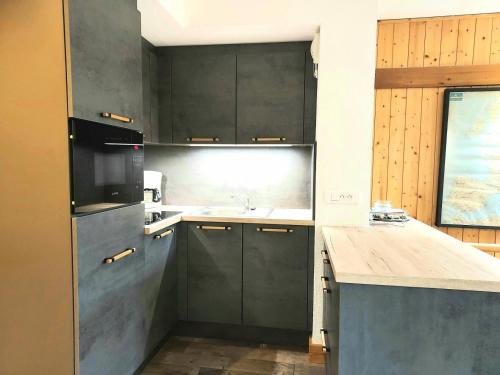 une cuisine avec des armoires grises et un évier dans l'établissement Résidence Doronic - Résidence DORONIC N°831 MAE-8311, à La Plagne Tarentaise