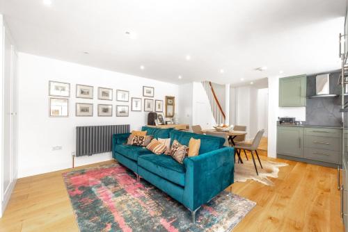 a living room with a blue couch and a table at Mount Auldyn House - The Cottage in Ramsey