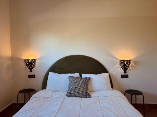 a bedroom with a bed with two lights on the wall at Apartment in front sania Ramel Airport 3 min walking in Tetouan