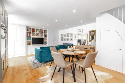 a living room with a blue couch and a table at Mount Auldyn House - The Cottage in Ramsey