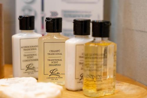 three bottles of soap sitting on a wooden table at Pao Pao Hotel Islas del rosario in Isla Grande