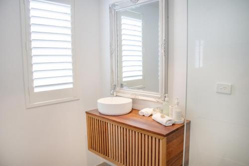a bathroom with a sink and a mirror at Midd's on the Beach - luxury beach front apartment in Albany