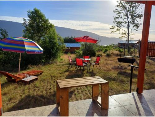 a patio with chairs and tables and umbrellas at Cabaña Moebius Conaripe in Panguipulli