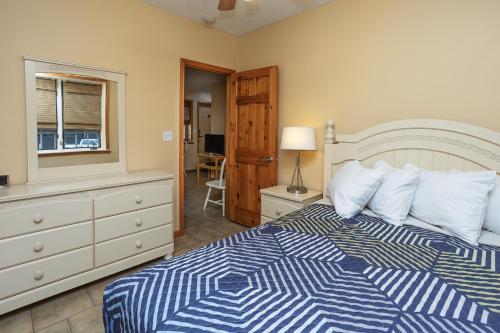 a bedroom with a blue and white bed and a dresser at Bridge Inn in Michigan City
