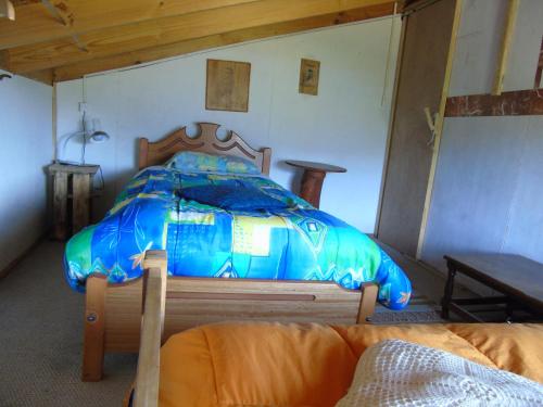 a blue bed in a room with a couch at Habitación Martin Pescador en Casa Quilanto in Coihaique