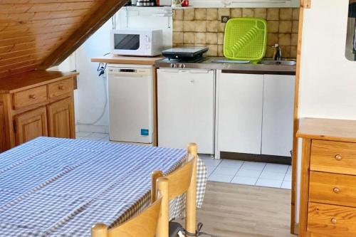 Il comprend une petite cuisine équipée d'appareils électroménagers blancs et d'un four micro-ondes. dans l'établissement Appartement confortable à Bagnères-de-Luchon - Vue montagne, à Luchon