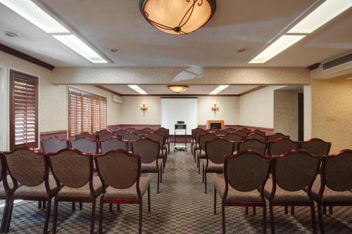 a conference room with chairs and a white screen at Hotel Piccadilly in Fresno