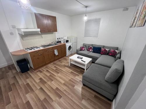 a living room with a couch and a kitchen at 1 bedroom apartment in Neepsend