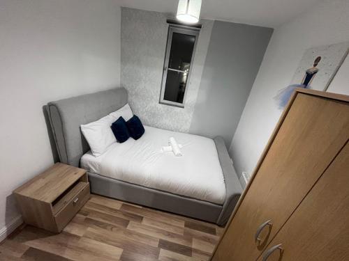 a small bedroom with a bed with blue pillows at 1 bedroom apartment in Neepsend