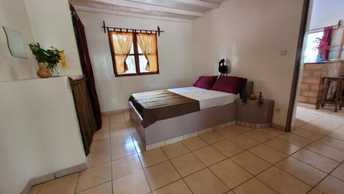 a bedroom with a bed in a room with a window at Kasa KAÏLO in Kafountine
