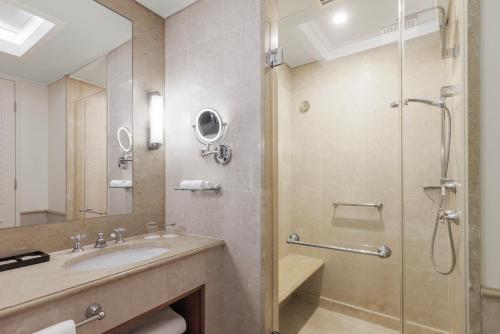 a bathroom with a sink and a shower at Pullman Reef Hotel Casino in Cairns