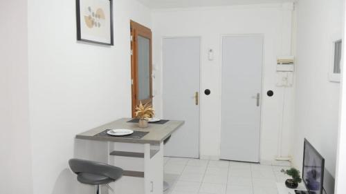 Una habitación blanca con un escritorio y una silla. en Le Bac D'Eragny, en Éragny