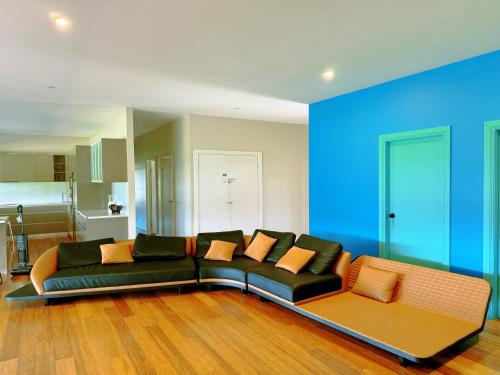 a living room with a black couch and orange pillows at Anna Bay 20 acres luxury farm in Salt Ash