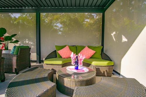 a patio with a couch and a table and chairs at Beach Cottage with heated pool just off Siesta Key in Sarasota