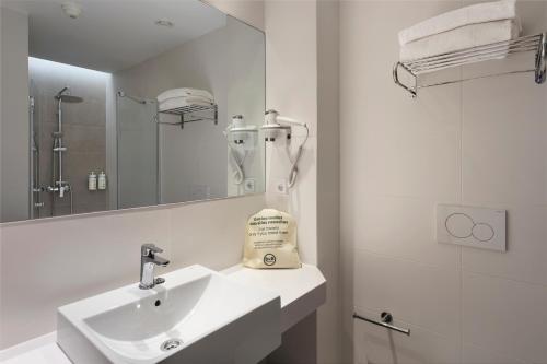 a white bathroom with a sink and a mirror at B&B HOTEL Madrid Carabanchel in Madrid