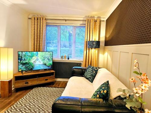 a living room with a couch and a flat screen tv at The Birch homely retreat in Middlesbrough