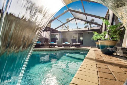 a swimming pool with a waterfall in a house at Beach Cottage with heated pool just off Siesta Key in Sarasota