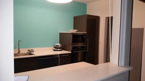 a kitchen with a sink and a refrigerator at Villa de standing avec piscine à Saint-François in Saint-François