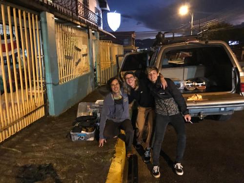 a group of three people standing next to a truck at In the Wind Hostel and Guesthouse in San José