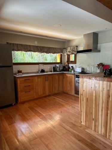 a kitchen with wooden cabinets and a wooden floor at El Pedregoso Cabaña del Lago in Cholila