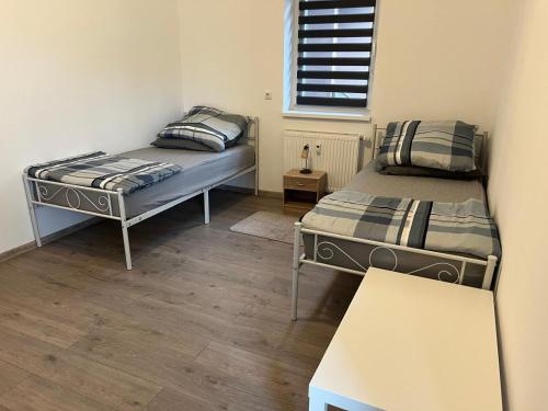 a room with two beds and a bench in it at Grosse Möblierte Wohnung Zu Vermieten an der BAB 15 in Kolkwitz