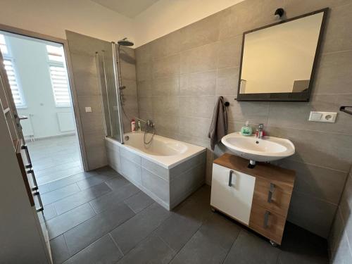 a bathroom with a sink and a tub and a mirror at Grosse Möblierte Wohnung Zu Vermieten an der BAB 15 in Kolkwitz