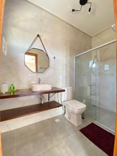 a bathroom with a sink and a shower and a toilet at Chalé Frutas Especiais in Mucugê