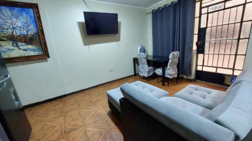 a living room with a couch and a tv at Carosvi Home in Lima