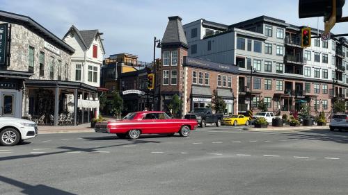 a red car is driving down a city street at King and Queen rooms -J&J Chilliwack in Chilliwack