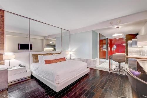 a bedroom with a large white bed with a glass wall at Stunning Escape Top Floor Strip-View Studio 31316 in Las Vegas