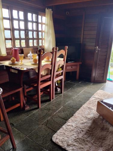 a dining room with a table and chairs and a table at Cabanas La Suisse in Campos do Jordão