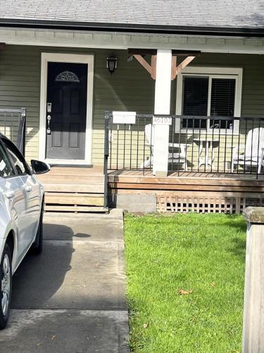 a car parked in front of a house with a porch at King and Queen rooms -J&J Chilliwack in Chilliwack