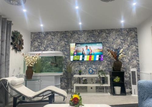 a living room with a tv on a wall at Igloo Magnolia Room Stay I Breakfast I Free Parking in Leeds