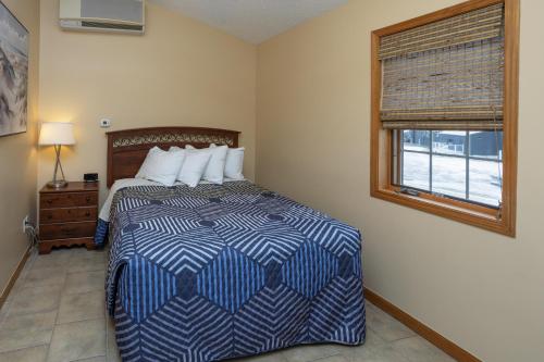 a bedroom with a bed with a blue and white comforter at Bridge Inn in Michigan City