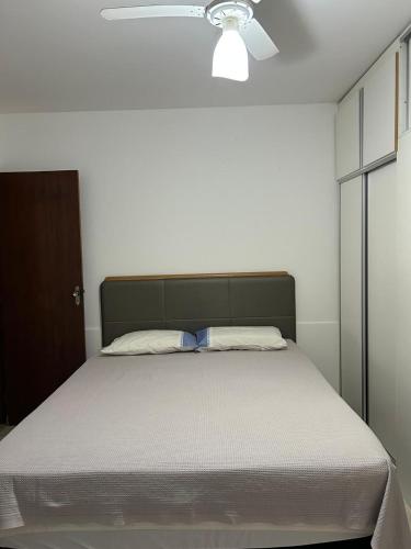 a bed in a bedroom with a ceiling fan at Casa na Praia da Pitoria in São Pedro da Aldeia