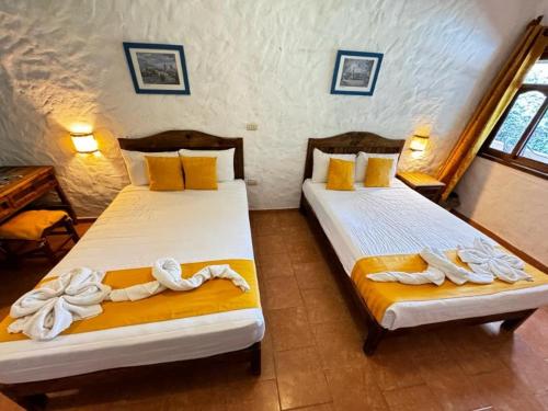 two beds in a room with towels on them at Posada La Querencia in Xico